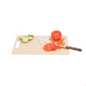 Corta verduras frescas en la tabla de cocina, lista para preparar una ensalada saludable.